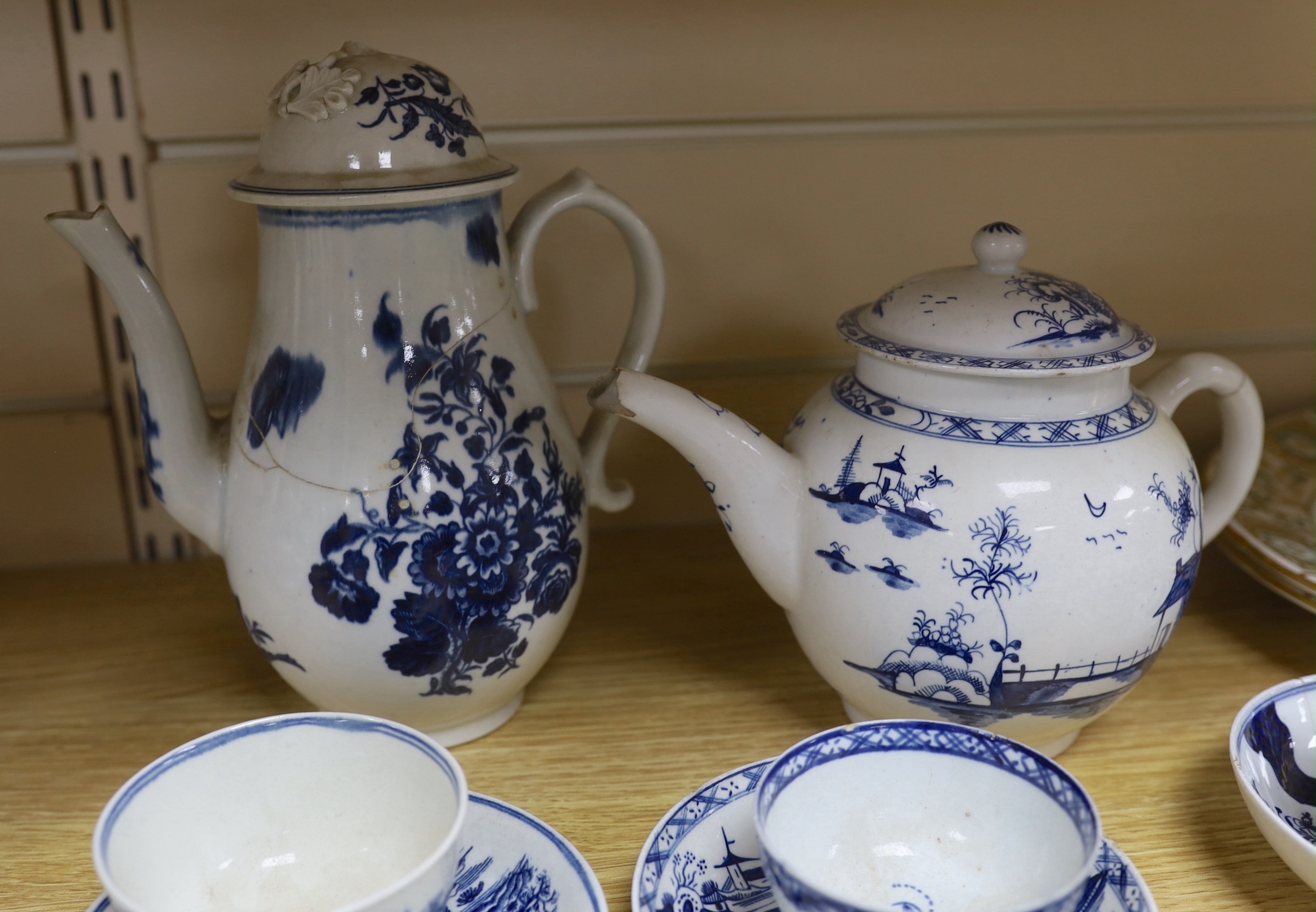 A collection of 18th century Worcester and Lowestoft blue and white tea and coffee wares, including a Lowestoft long fence pattern teapot and cover and a similar tea bowl and saucer